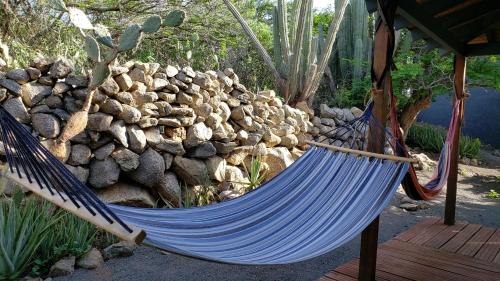 a blue hammock in front of a pile of rocks at Jamanota Happy View in Boton