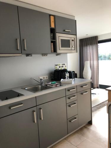 a kitchen with a sink and a microwave at City-Apparte ONE Zentrales & komfortables Wohnen in Gronau in Gronau