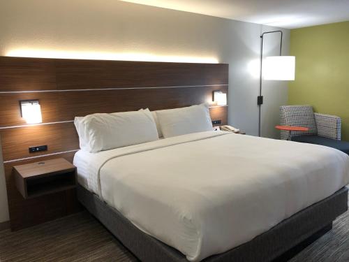 a bed in a hotel room with a large white bed at Holiday Inn Express Atlanta-Stone Mountain by IHG in Stone Mountain