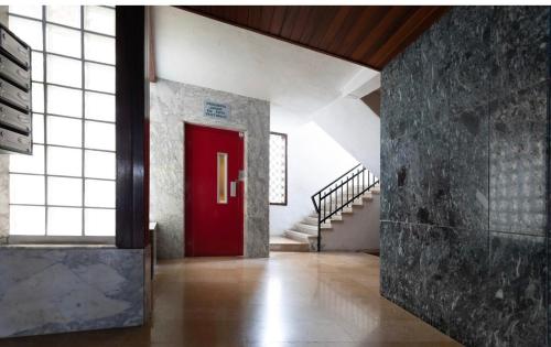 a red door in a building with a staircase at Calafell playa lateral mar in Calafell
