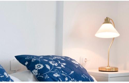 a lamp sitting on a night stand next to a bed at Calafell playa lateral mar in Calafell