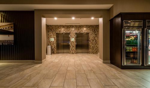 an empty lobby with two elevators in a building at Holiday Inn Austin Airport by IHG in Austin