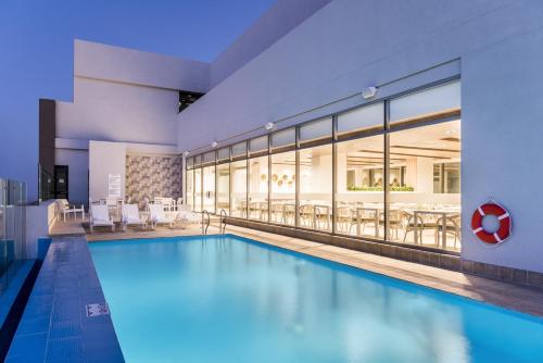 a swimming pool in a building with a restaurant at Holiday Inn Express - Barranquilla Buenavista by IHG in Barranquilla