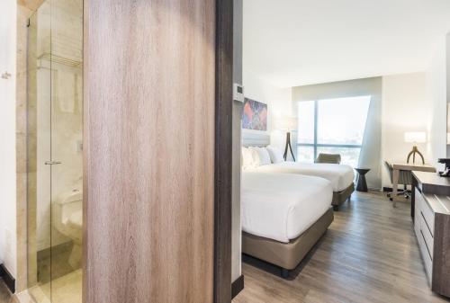 a hotel room with two beds and a bathroom at Holiday Inn Express - Barranquilla Buenavista by IHG in Barranquilla