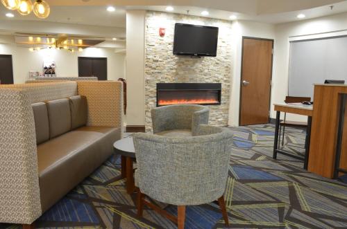 a lobby with a couch and chairs and a fireplace at Holiday Inn Express- Waterloo/Cedar Falls by IHG in Waterloo