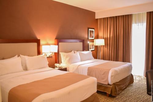 a hotel room with two beds and a window at Holiday Inn Leon by IHG in León