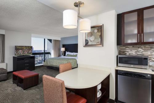a hotel room with a bed and a living room at Staybridge Suites Atlanta - Midtown by IHG in Atlanta