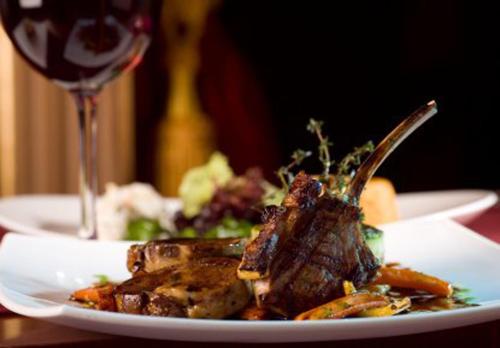 a plate of food on a table with a glass of wine at Hotel Airlink Castle in Nedumbassery