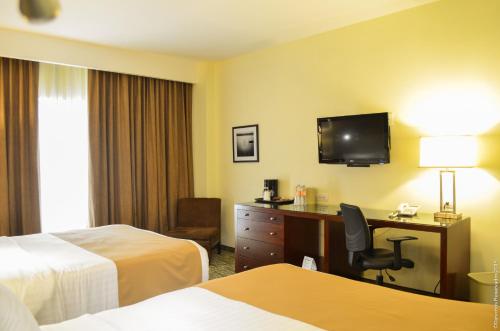 a hotel room with a desk and a television at Holiday Inn Leon by IHG in León