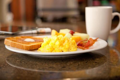 a plate of breakfast food and a cup of coffee at Staybridge Suites Atlanta - Midtown by IHG in Atlanta