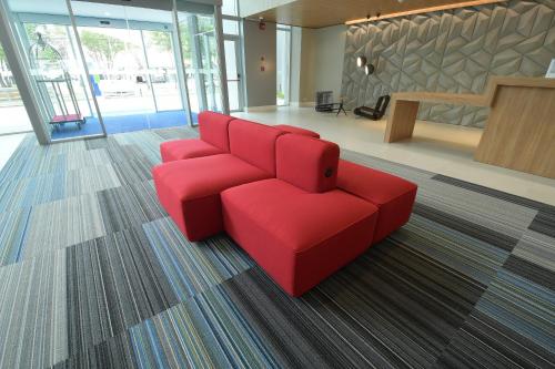 a red couch in a room with a lobby at Holiday Inn Express Asuncion Aviadores by IHG in Asuncion