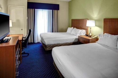 a hotel room with two beds and a flat screen tv at Holiday Inn Express Ashland by IHG in Ashland