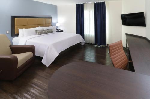 a hotel room with a bed and a tv at Candlewood Suites - Celaya by IHG in Celaya