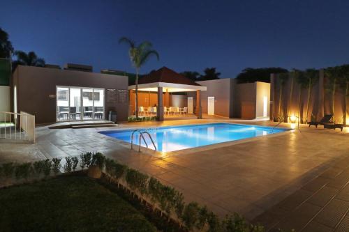 a swimming pool in front of a house at night at Candlewood Suites - Celaya, an IHG Hotel in Celaya