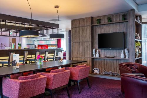 a dining room with a table and chairs and a tv at Holiday Inn Express Amsterdam - Sloterdijk Station by IHG in Amsterdam