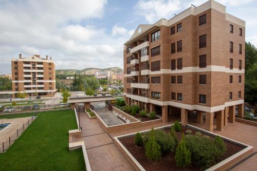 an apartment building with a lawn in front of it at Cubell Home in Cuenca