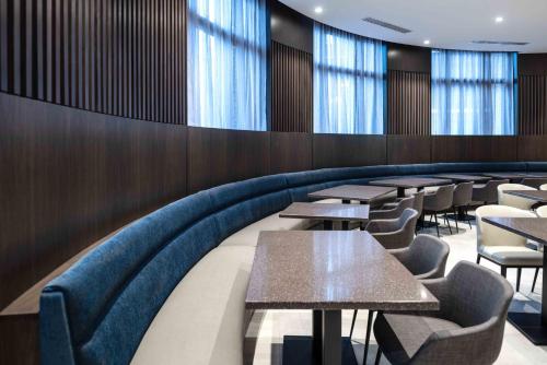 a dining room with tables and chairs and windows at Holiday Inn Express - Boston South - Quincy by IHG in Quincy