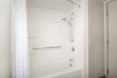 a bathroom with a shower and a white tub at Holiday Inn Express Andover North - Lawrence by IHG in Lawrence