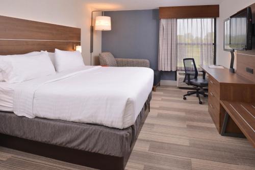 ein Hotelzimmer mit einem Bett, einem Schreibtisch und einem TV in der Unterkunft Holiday Inn Express Olean, an IHG Hotel in Olean
