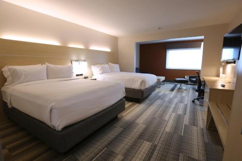 a hotel room with two beds and a television at Holiday Inn Express - Biloxi - Beach Blvd by IHG in Biloxi