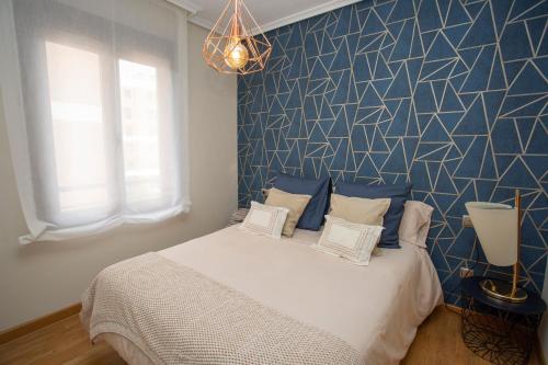 1 dormitorio con 1 cama con pared azul en Cubell Home, en Cuenca