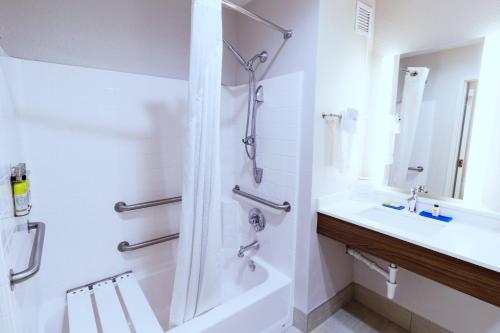 a white bathroom with a shower and a sink at Holiday Inn Express Hotel & Suites Crestview South I-10 by IHG in Crestview