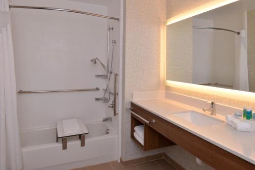 uma casa de banho com um lavatório, um chuveiro e um espelho. em Holiday Inn Express Olean, an IHG Hotel em Olean