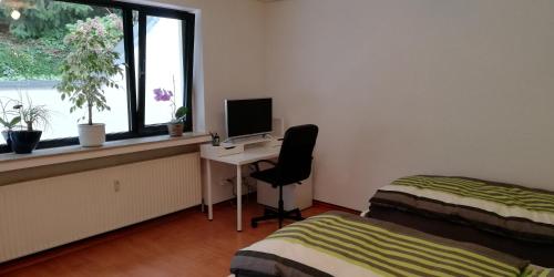um quarto com uma secretária, um computador e uma janela em Ferienwohnung Sonnwald em Dusseldorf