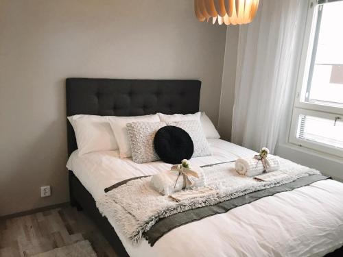 Una cama con dos toallas y un sombrero. en Hostit cozy apartment en Rovaniemi