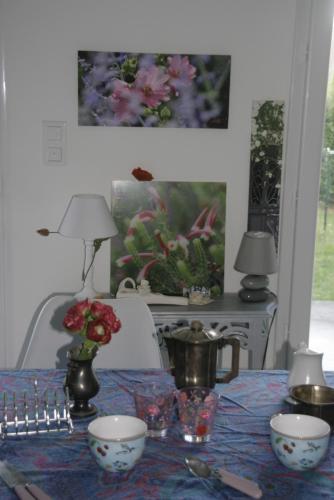 une table avec un chiffon bleu et des fleurs sur elle dans l'établissement entre terre et mer, à Nozay