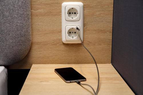 a phone plugged into an electrical outlet on a wall at Holiday Inn Express Cologne Troisdorf by IHG in Troisdorf
