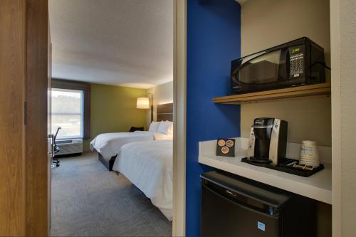 a hotel room with a bedroom with a bed and a tv at Holiday Inn Express - Horse Cave by IHG in Horse Cave