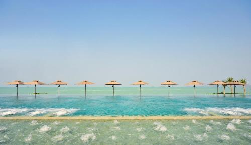 a row of umbrellas in the water on a beach at Hansar Samui Resort & Spa - SHA Extra Plus in Bophut 