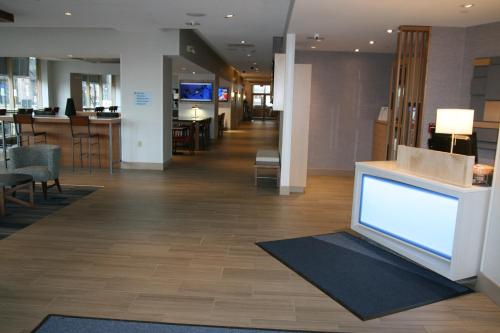 a lobby with a large tv in the middle of a building at Holiday Inn Express & Suites Buffalo Downtown by IHG in Buffalo