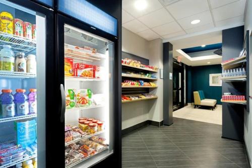 an open refrigerator in a store with food at Holiday Inn Express and Suites Batavia by IHG in Batavia