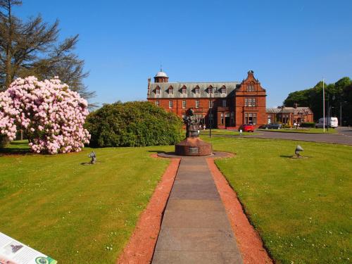 a building with a statue in the middle of a park at Holiday Inn Dumfries by IHG in Dumfries