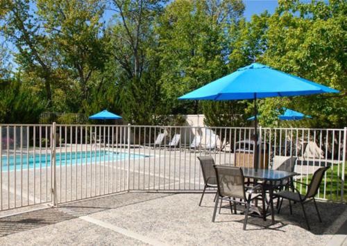 a table and chairs with a blue umbrella next to a pool at Holiday Inn Express Boise Downtown by IHG in Boise