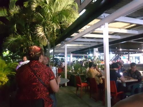 um grupo de pessoas sentadas em mesas em um restaurante em Hotel Millenia Samoa em Apia