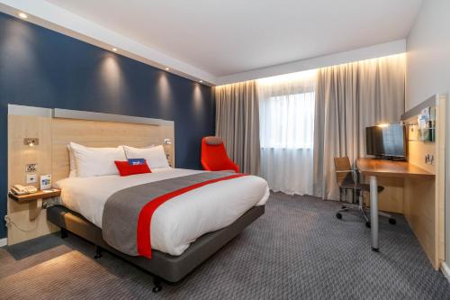 a hotel room with a large bed and a desk at Holiday Inn Express Walsall M6, J10 by IHG in Walsall