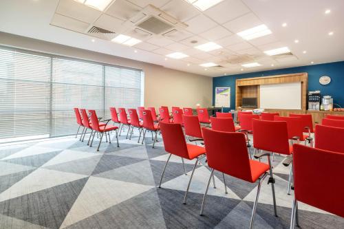 a conference room with red chairs and a whiteboard at Holiday Inn Express Walsall M6, J10 by IHG in Walsall