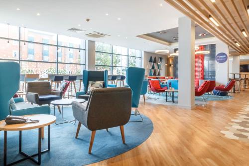 a waiting room with chairs and tables and windows at Holiday Inn Express Walsall M6, J10 by IHG in Walsall