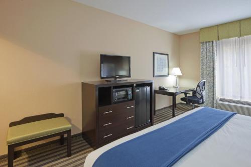 a hotel room with a bed and a tv and a desk at Holiday Inn Express Columbia by IHG in Columbia