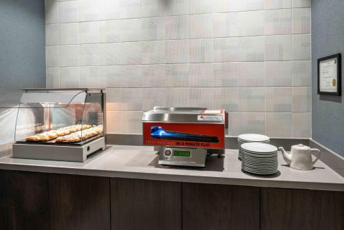 a coffee maker and plates on a counter in a restaurant at Staybridge Suites - Quincy by IHG in Quincy