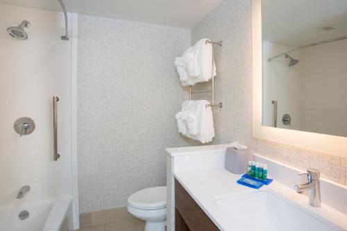 a bathroom with a sink and a toilet and a mirror at Holiday Inn Express Chelmsford, an IHG Hotel in Chelmsford