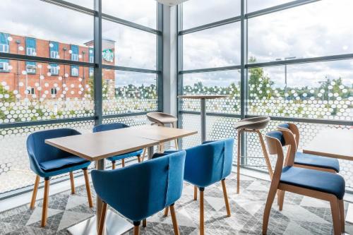 a table and chairs in a room with large windows at Holiday Inn Express Walsall M6, J10 by IHG in Walsall
