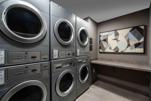 a laundry room with four washing machines and a counter at Staybridge Suites - Quincy by IHG in Quincy
