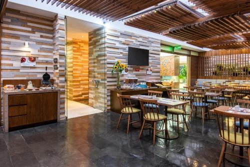 Un restaurante con mesas y sillas y un televisor de pantalla plana. en Holiday Inn Express Bogotá - Parque La 93 by IHG, en Bogotá