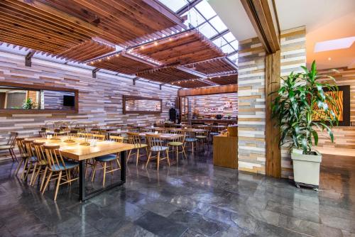 Un comedor con mesas y sillas de madera. en Holiday Inn Express Bogotá - Parque La 93 by IHG, en Bogotá