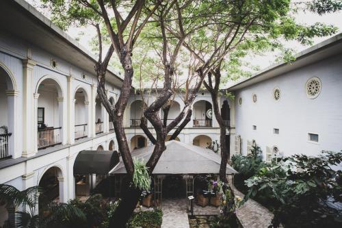 a large building with a tree in the courtyard at Hotel del Parque in Guayaquil