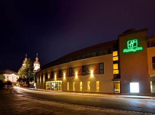 a building with a sign on the side of it at night at Holiday Inn Trnava by IHG in Trnava